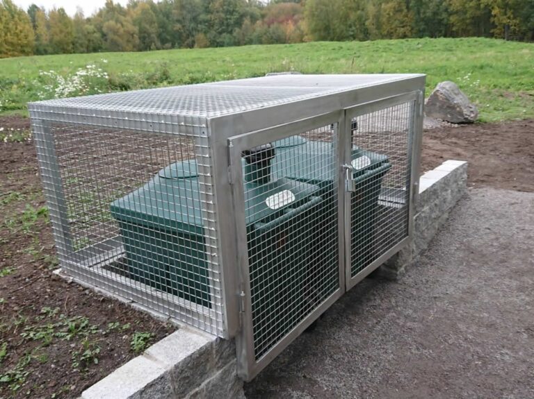 Green Toilet containers in a mesh service enclosure behind the Helsinki Huussi.